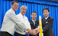 H3ロケットの打ち上げに成功し、記念写真に納まるJAXAの山川理事長（左から2人目）ら関係者（17日、種子島宇宙センター）