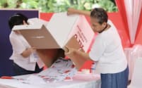 インドネシア大統領選で開票する投票所のスタッフら（2月14日、ジャカルタ）=小林健撮影