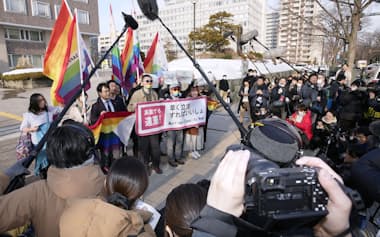 同性婚を巡る訴訟で初の高裁判断となった札幌高裁判決を受け、高裁前でメッセージを掲げる原告ら（14日午後）=共同