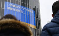 日銀がマイナス金利を解除したことを報じる街頭ニュース（19日、東京・渋谷）