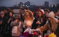 銃乱射があったモスクワ郊外のコンサートホール近くで犠牲者を追悼する人たち（23日）＝AP