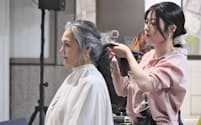 グレイヘアに合う髪形にセットしてもらう女性。つややまとまりのあるスタイルが似合うという＝日本グレイヘア協会提供