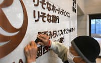関西みらいFGの本社内の壁から撤去される「関西みらいフィナンシャルグループ」の文字（29日、大阪市中央区）
