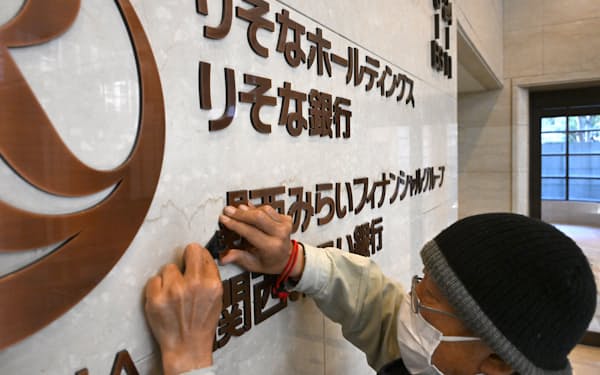 関西みらいFGの本社内の壁から撤去される「関西みらいフィナンシャルグループ」の文字（29日、大阪市中央区）