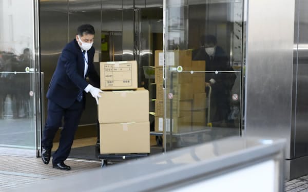 押収物を運ぶ警視庁の捜査員ら（29日午後、東京都新宿区）=共同