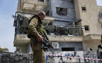 イスラエルとヒズボラの交戦が激化している（27日、イスラエル北部でレバノンから発射されたロケット弾の着弾地点を調べる治安部隊）＝ＡＰ