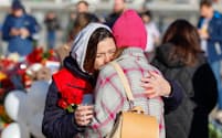 モスクワ郊外の銃乱射テロ現場を犠牲者追悼のため訪れ、抱き合う女性ら（27日）＝タス共同