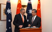 オーストラリアのアルバニージー首相㊧と中国の王毅（ワン・イー）共産党政治局員兼外相。両国の貿易を巡る対立は収束しつつある＝ロイター