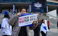 大リーグ開幕戦の球場に駆けつけた韓国人の野球ファン。掲げているポスターに「野球天才・大谷、顔も天才・大谷」と書かれている（3月20日、ソウル）