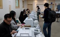 韓国総選挙の事前投票の様子。投票用紙を印刷する機械が並ぶ（5日、ソウル）