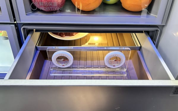 中国ハイアールグループが展示した新型冷蔵庫のチルド室。方位磁石が2個、アクリルのパネルに固定されている（写真:日経クロステック）