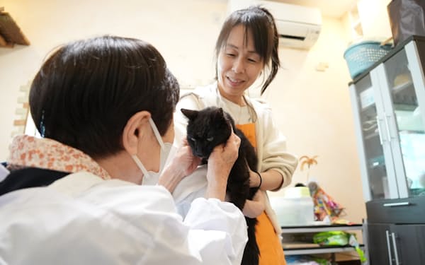 ペット預かりサービスで愛猫と面会する女性㊧（東京都大田区）