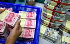 FILE PHOTO: A bank employee counts China?s renminbi (RMB) or yuan notes next to U.S. dollar notes at a Kasikornbank in Bangkok, Thailand, January 26, 2023. REUTERS/Athit Perawongmetha/File Photo
