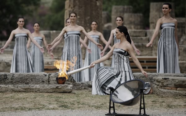 パリ五輪の聖火採火式で聖火に点火するギリシャの女優メアリー・ミナさん（16日、ギリシャ・オリンピア）=ロイター