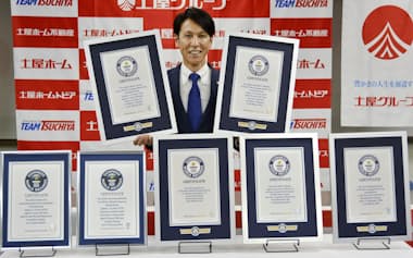 七つのギネス世界記録の公式認定証と写真に納まるノルディックスキー・ジャンプ男子の葛西紀明（17日、札幌市内）=共同