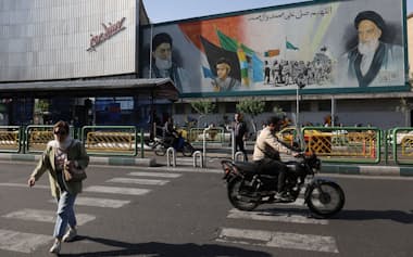 イランの街頭で建物に描かれた指導者らの壁画（15日、テヘラン）=ロイター
