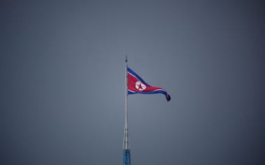 南北軍事境界線の北側にある北朝鮮の「宣伝村」に掲げられた国旗。韓国側から撮影された（2022年7月）=ロイター