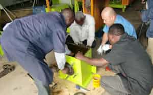 タンザニアで機械組み立ての研修をする上杉社長(右から2人目)