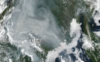 2021年７月のシベリア森林火災の衛星写真。煙が広範囲を覆う。右に見えるのはカムチャツカ半島＝米航空宇宙局（NASA）提供