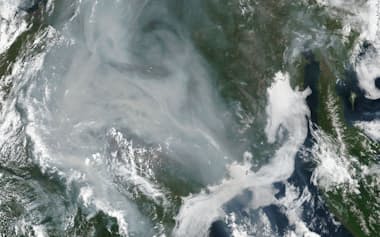 2021年7月のシベリア森林火災の衛星写真。煙が広範囲を覆う。右に見えるのはカムチャツカ半島=米航空宇宙局（NASA）提供