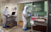 新型コロナウイルスに感染した患者の病室前で作業する看護師（9日、大阪府守口市の守口生野記念病院）