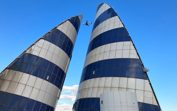 東京湾アクアラインの「風の塔」の上空を飛ぶ羽田空港発着の航空機