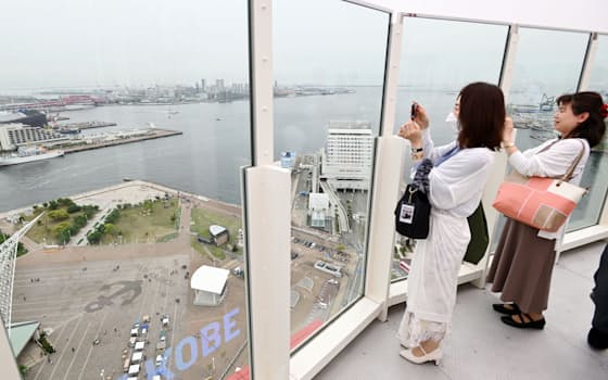 神戸ポートタワーの屋上デッキで眺めを楽しむ人たち（26日午前、神戸市中央区）