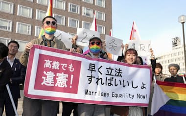同性婚に関する札幌高裁の違憲判決を受け、メッセージを掲げる原告ら（3月14日)