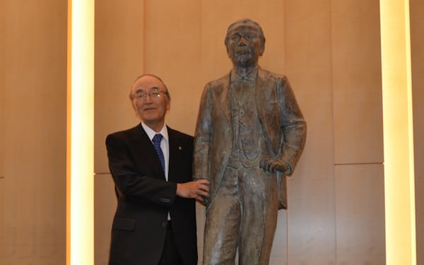 東商ビル１階に置かれた渋沢栄一像と筆者