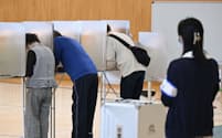 衆院島根1区補欠選挙で、投票用紙に記入する有権者（28日、松江市）=共同