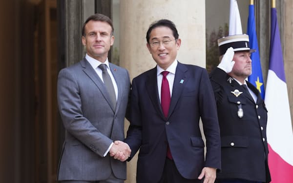 会談前にフランスのマクロン大統領（左）と握手する岸田首相（2日、パリの大統領府）=共同