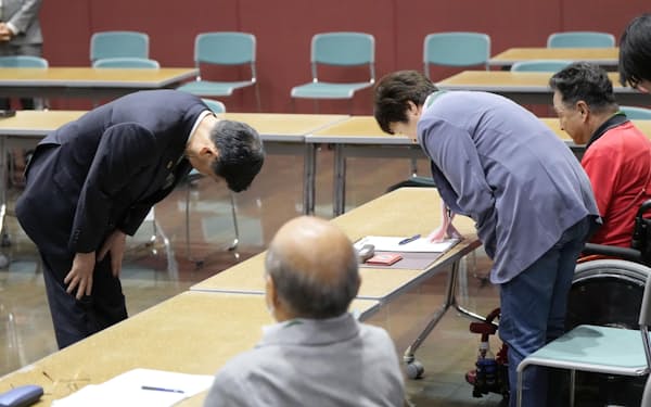 水俣病の患者・被害者らへの謝罪に訪れ、頭を下げる伊藤環境相（左）（8日午後、熊本県水俣市）=共同