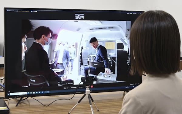 投票所の立会人と同じ目線で投票リハーサルを見守るオンライン立会人(5月、鳥取県智頭町)=共同