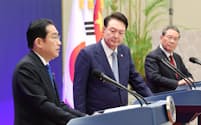 日中韓サミット後の共同記者発表で発言する岸田首相(左)。中央は韓国の尹錫悦大統領、右は中国の李強首相(27日、ソウル)=代表撮影・共同