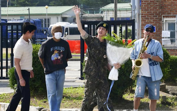 12日に韓国・京畿道漣川で兵役を終え、BTSの他のメンバーらに出迎えられたジンさん(右から2人目)=共同