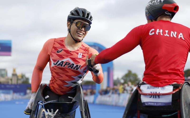 男子マラソン(車いすT54) ゴール後、健闘をたたえ合う鈴木朋樹(左)。銅メダルを獲得した=パリ(共同)