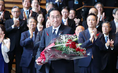 官邸職員から贈られた花束を手にする岸田首相(1日、首相官邸)
