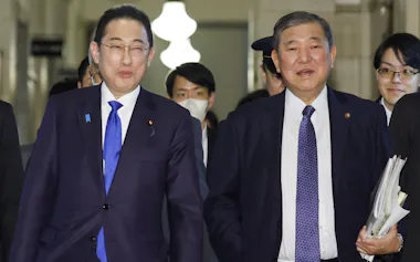 衆院予算委での質疑を終え、自民党の石破元幹事長(右)と言葉を交わしながら歩く岸田首相(14日)