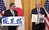 日米首脳会談後、トランプ氏(右)が首相に手渡したメッセージ(7日、ワシントン)=AP
