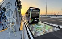 大阪・関西万博の東ゲート北停留所の道路には、走行中ワイヤレス給電(DWPT)をイメージしただまし絵が描かれている。だまし絵の前方に送電コイルユニットが1つ埋設してある(写真:日経クロステック)