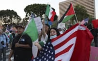 米移民・税関捜査局による強制捜査に抗議するデモ参加者ら(12日、ロサンゼルス)=AP
