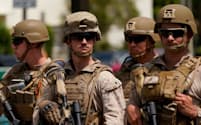 13日、ロサンゼルスの連邦政府施設の外を警護する米海兵隊員=ロイター