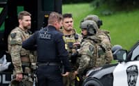 Officers communicate in a staging area after what police said was a targeted shooting in the area around Edinburgh Golf Course in the Minneapolis suburb of Brooklyn Park, Minnesota, U.S. June 14, 2025. REUTERS/Ellen Schmidt