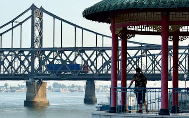 中国と北朝鮮の国境にかかる鉄橋を通行するトラック(7月上旬、遼寧省丹東市から撮影)