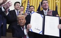 ジーニアス法の署名式にのぞんだトランプ米大統領(18日、ホワイトハウス)=AP