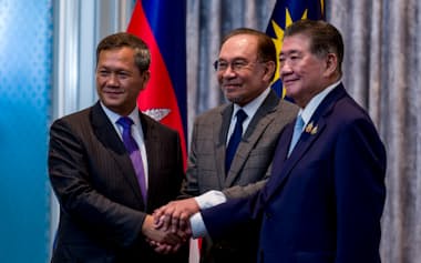 握手するタイのプムタム首相代行㊨、カンボジアのフン・マネット首相㊧と、仲介したマレーシアのアンワル首相(28日、クアラルンプール近郊)=マレーシア首相府提供