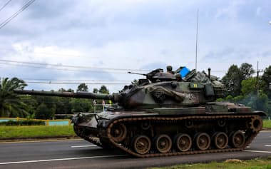 タイとカンボジアの国境に向かう戦車(28日、シーサケート県)=ロイター