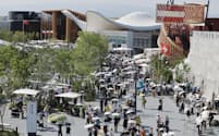 大阪万博の会場内を日傘を差して歩く人たち(5日、大阪市此花区)