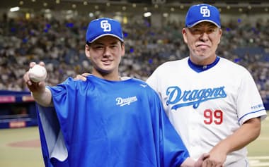 登板10試合目となった7日の阪神戦でプロ初勝利を挙げ、井上監督(右)とポーズをとる中日・金丸=共同