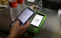 PIXで支払いを済ませる消費者。スマホでQRコードを読み込めば、決済口座から瞬時に資金を移動できる(ロイター)